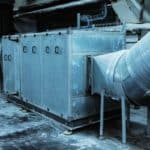 Grande Unité Industrielle De Ventilation Ou De Cvc Avec Des Conduits Métalliques Raccordés Dans Une Installation Intérieure, Entourée D'un Sol Et De Murs En Béton.