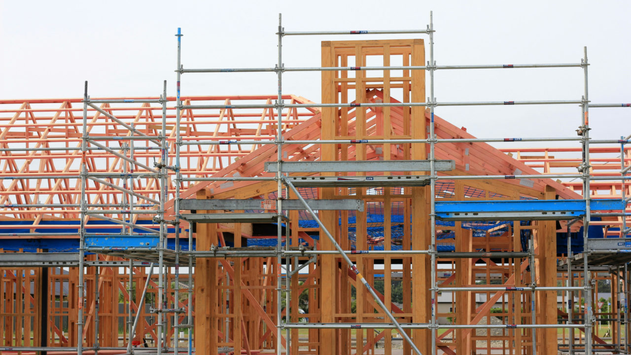Charpente De Maison En Bois En Cours De Construction, Avec échafaudages Et Poutres Structurelles Visibles, Sans Murs Ni Toit Encore Achevés.
