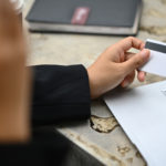 Cropped Shot Of Young Woman Holding Credit Card And Calling To Bank Or Customer Service